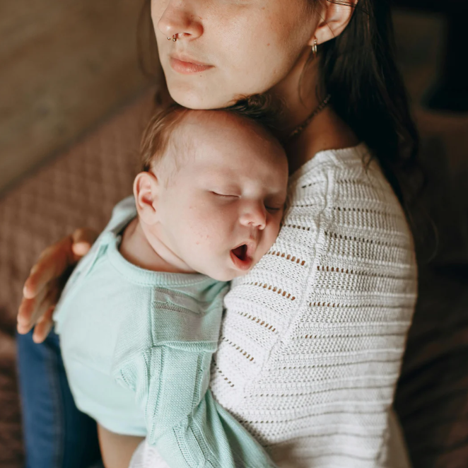 baby sleeping on mother